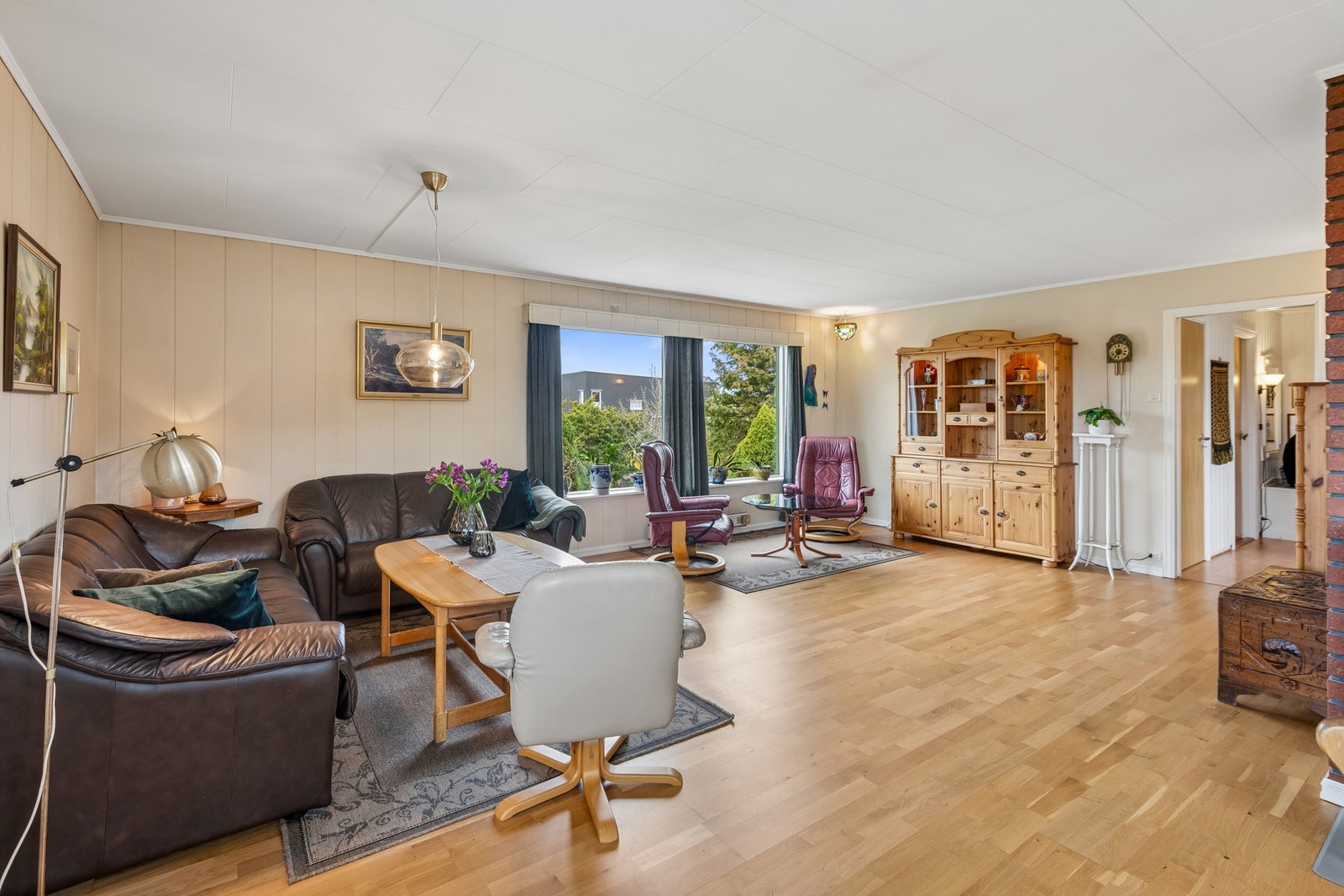 Store vindusflater på stue som slipper inn rikelig med naturlig lys. Galleribilde