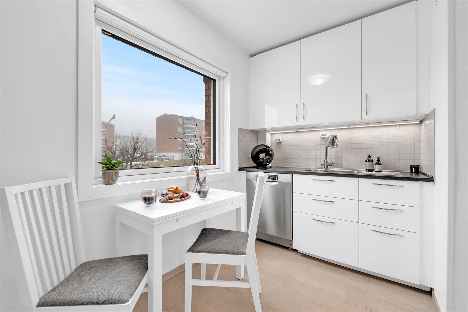 Kjøkkenet har en hyggelig spiseplass ved vinduet, perfekt for hverdagens måltider. Galleribilde