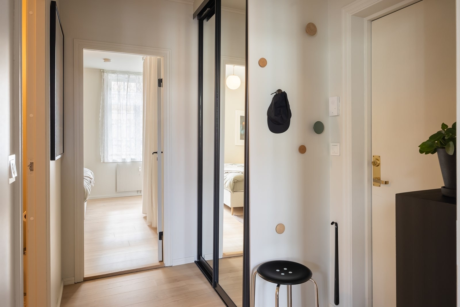Entré på 4,5 m². Det ble satt inn plassbygd skyvedørsgarderobe med sorte profiler og speil i 2019 med gode oppbevaringsmuligheter til yttertøy. Galleribilde