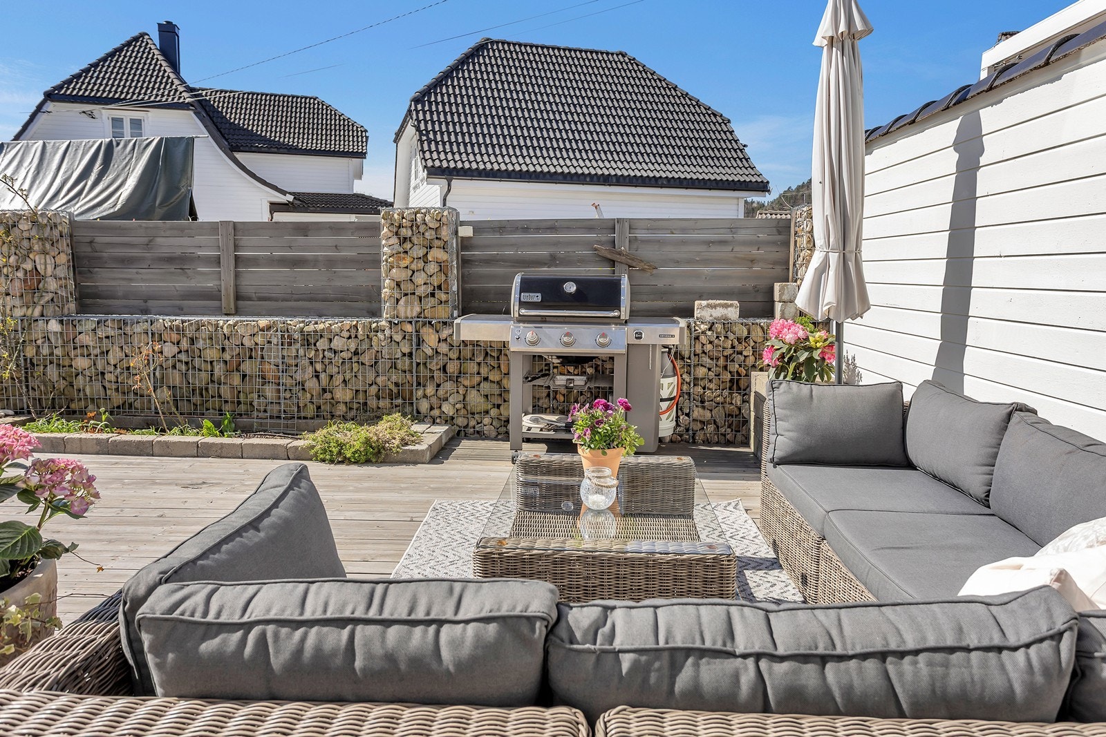 Terrasse med sofagruppe og grillområde, tilrettelagt for utendørs hygge. Galleribilde