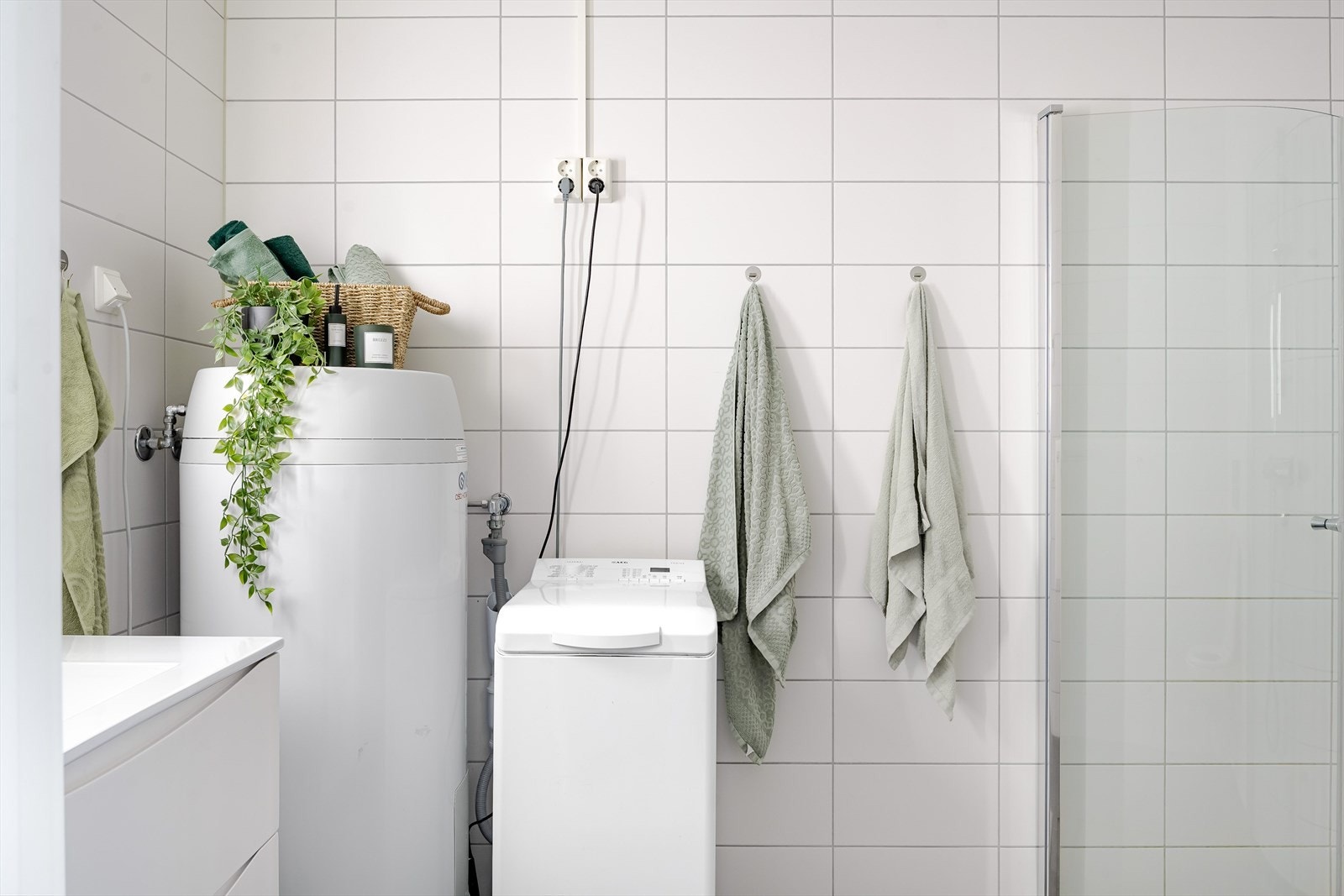 Baderommet er også utstyrt med dusjhjørne med innfellbare glassdører, veggmontert toalett, opplegg for vaskemaskin og varmtvannsbereder. Galleribilde