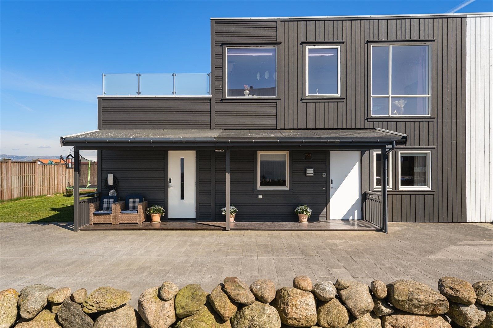 Moderne fasade med en kombinasjon av stående og liggende trepanel. Galleribilde
