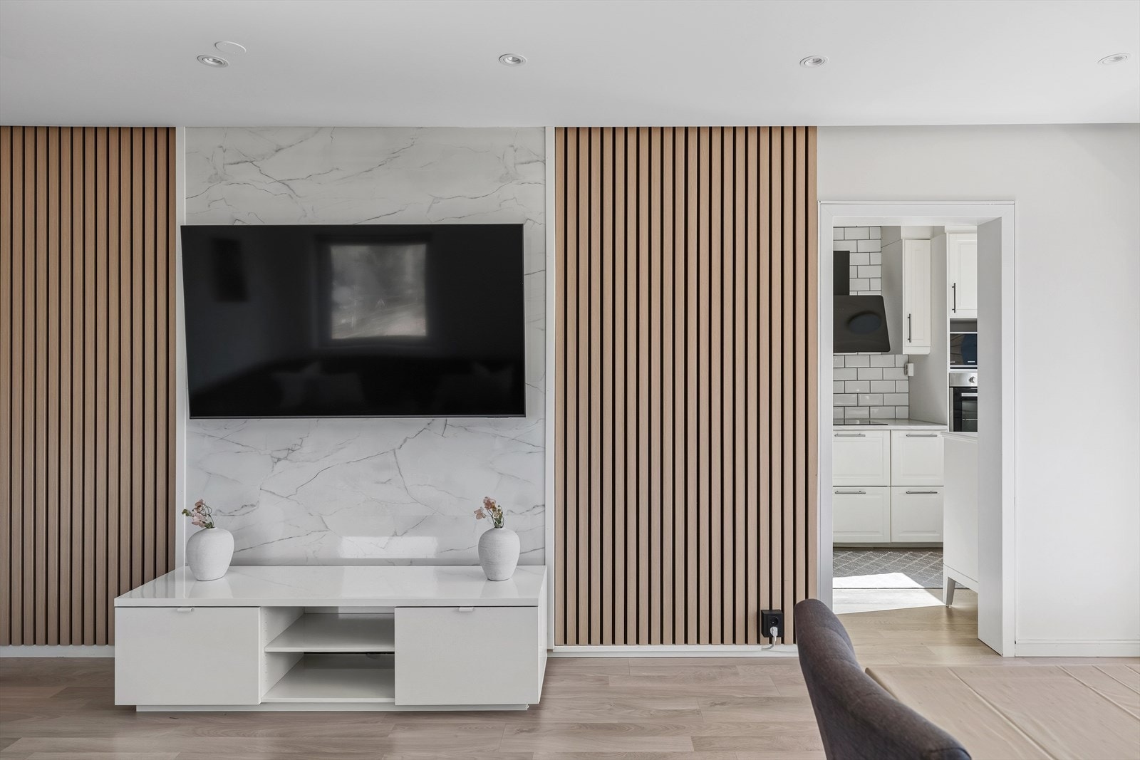 Stuen har et moderne uttrykk med lekker spilekledning på veggen og plate med marmorprint - det perfekte sted for oppheng av TV! Galleribilde