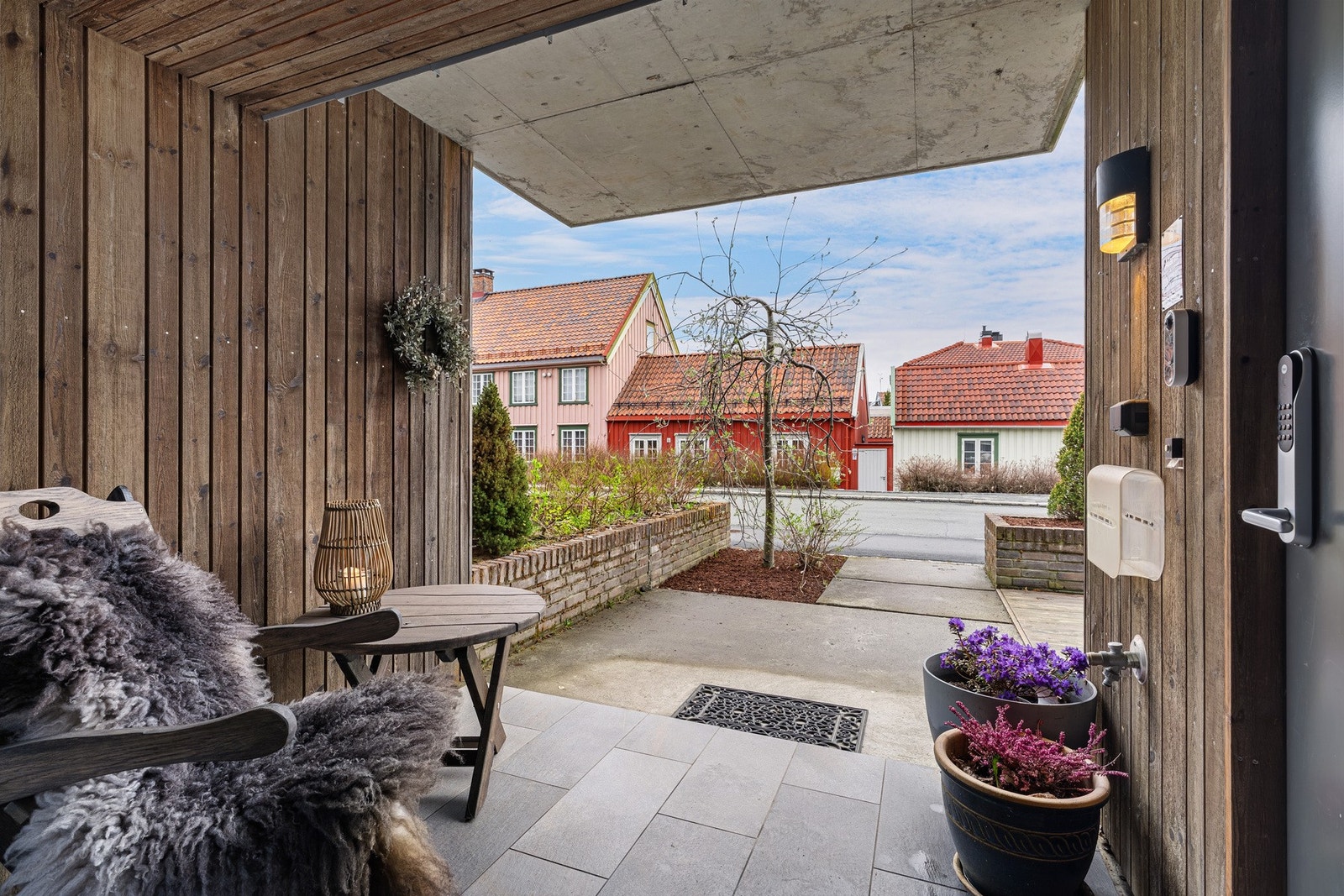 Inngangspartiet vender mot nord fra Mellomila og ønskes velkommen av en sjarmerende forhage. Forhagen skaper en behagelig avstand til gaten, som gir en lun og privat atmosfære ved inngangen. Galleribilde