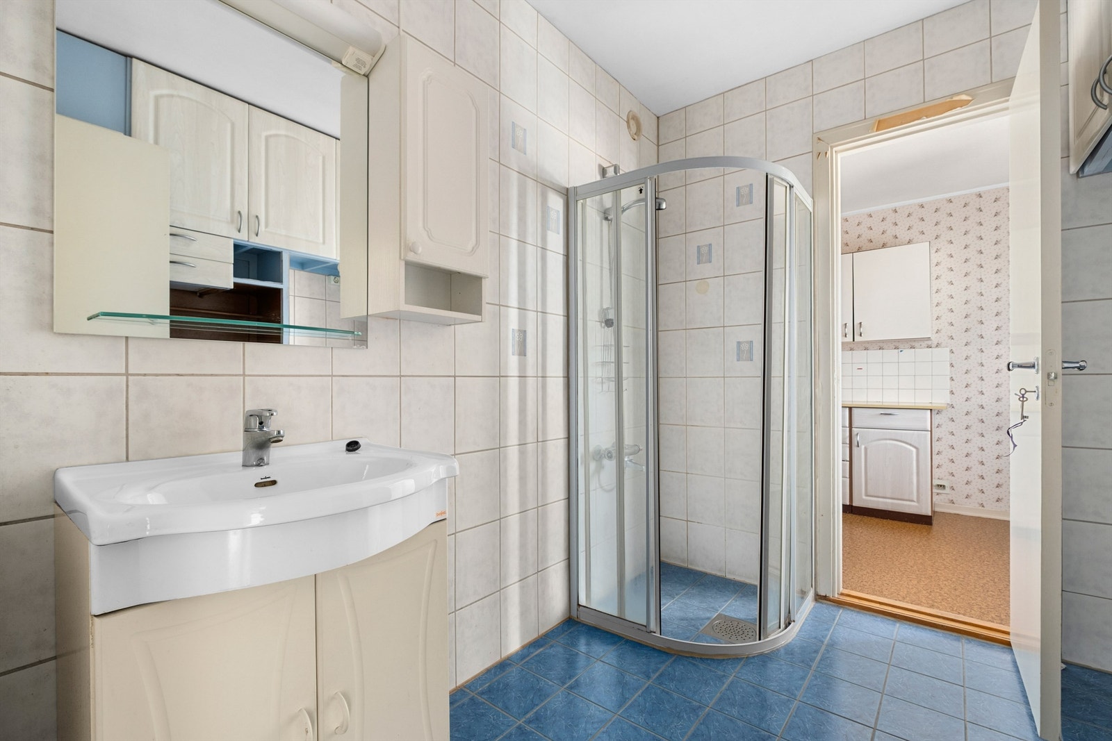 Badet måler 5 kvm og er innredet med servantskap med speil og lys, opplegg for oppvaskmaskin og dusjhjørne. I tillegg har leiligheten separat toalettrom. Det må påregnes noe oppussing. Galleribilde