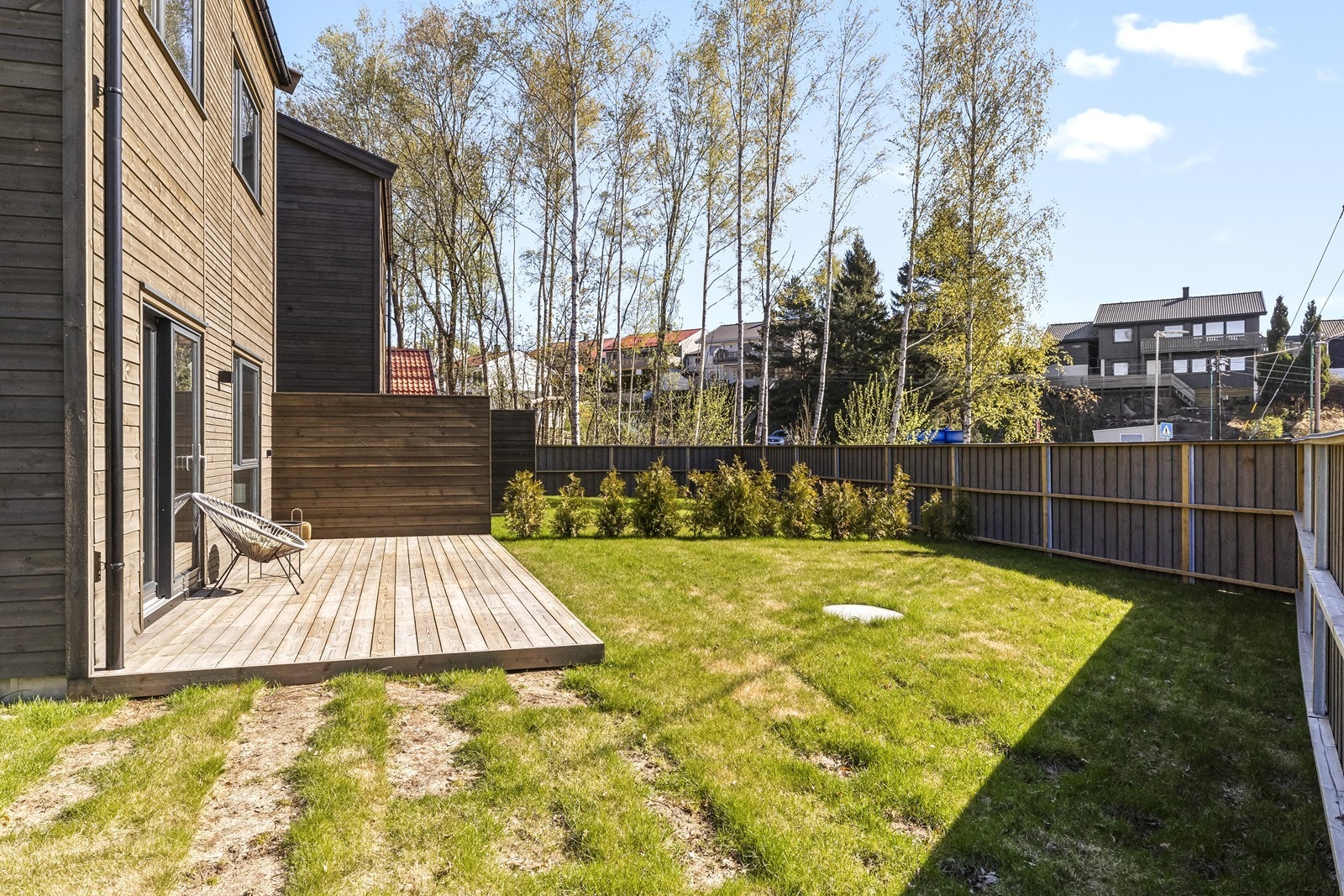 Uteområdet er pent opparbeidet og rammet inn med gjerde og hekk Galleribilde