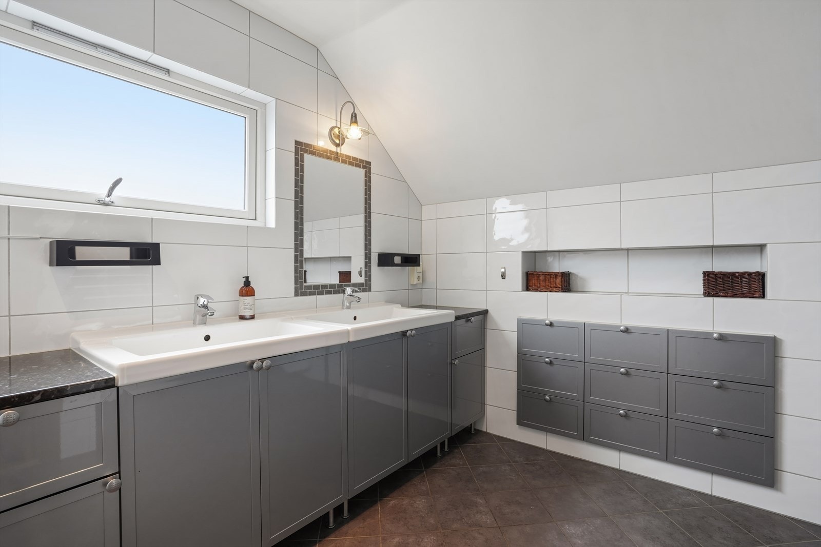 Badet i loftsetasjen har smarte nisjer for oppbevaring og et stort vindu som gir godt med dagslys. Galleribilde