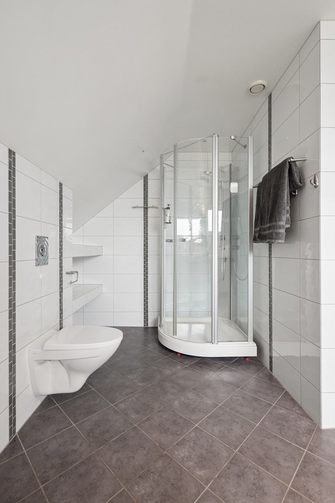 Badet i loftsetasjen ble oppusset i 2008 og har fliser med varmekabler i gulvet, vegghengt toalett og dusjkabinett. Galleribilde