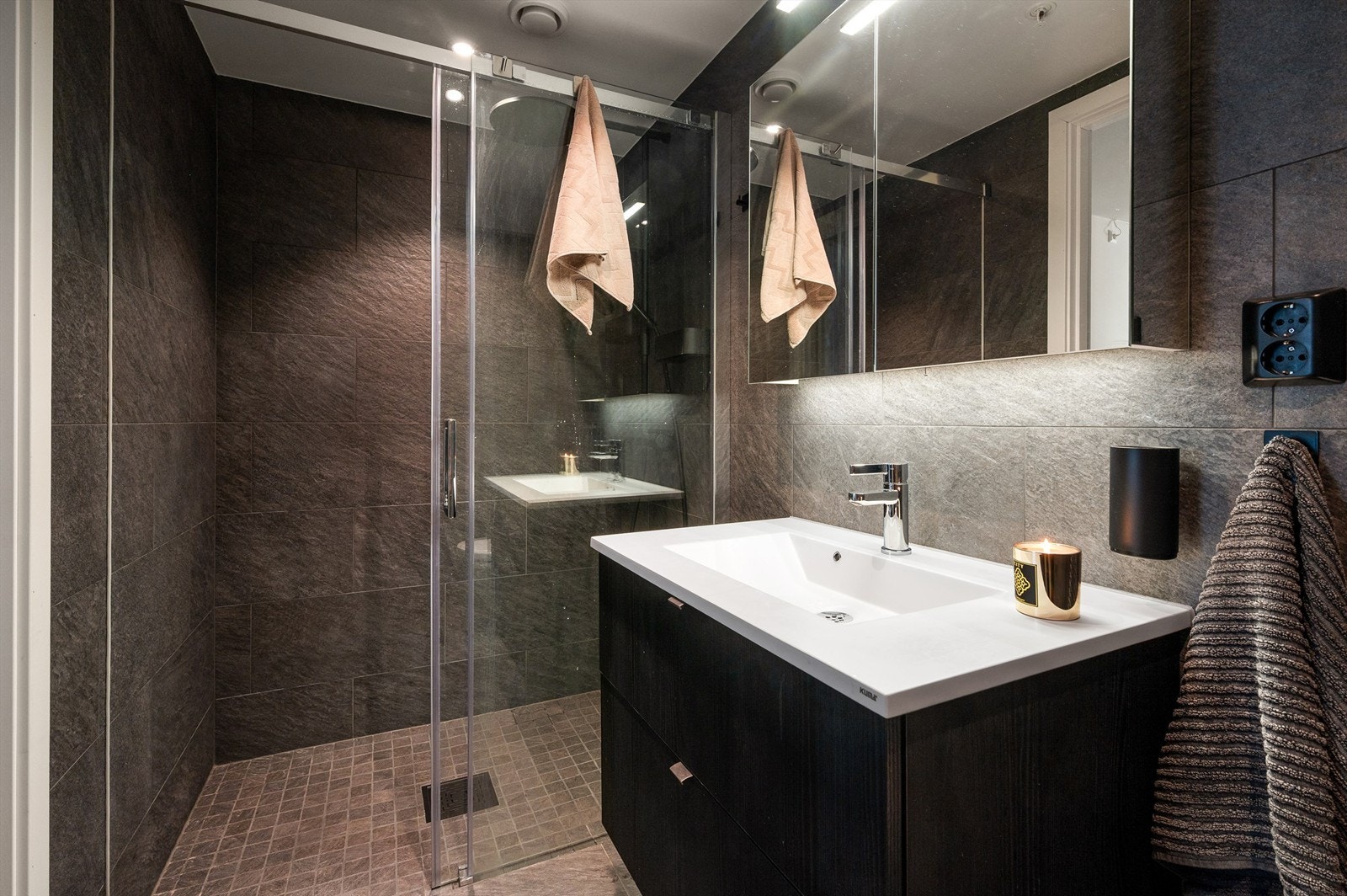 Det andre badet har adkomst fra hovedsoverromet. Overflatene er mørke og er stilfullt innredet med store, grå vegg- og gulvfliser. Skikkelig spafølelse! Galleribilde