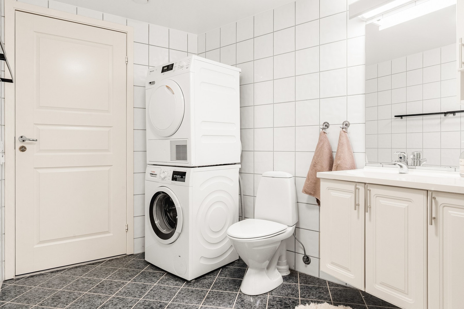 Badet er innredet med dusjkabinett, toalett og baderomsinnredning, samt opplegg for vaskemaskin. Galleribilde