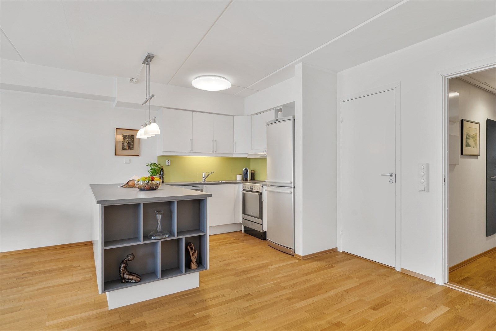 Kjøkken med stor påkostet kjøkkenøy som tar seg godt ut. Galleribilde