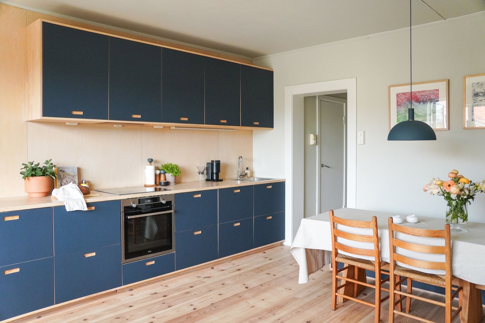 Romslig åpent kjøkken med plass til stort spisebord. Den dype blåfargen er gjennomgående i overflater og detaljer i hele leiligheten. Galleribilde