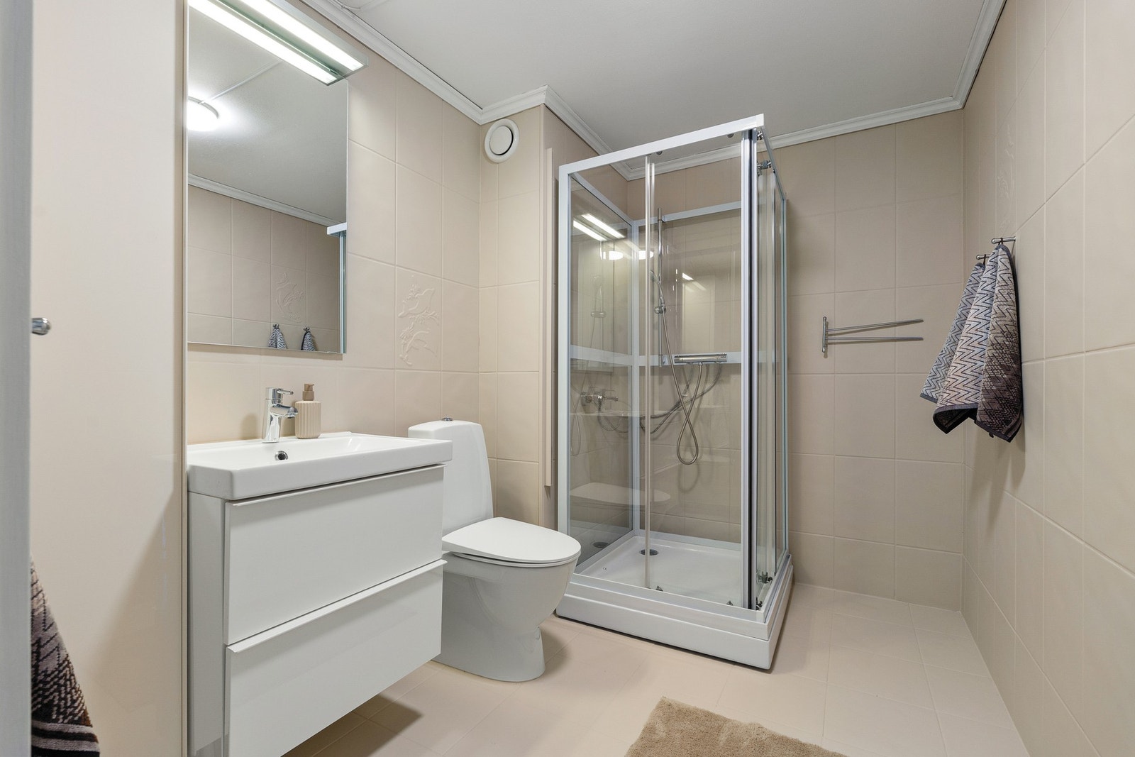 Flott flislagt baderom med praktisk dusjkabinett. Badet har nylig blitt malt opp. Galleribilde