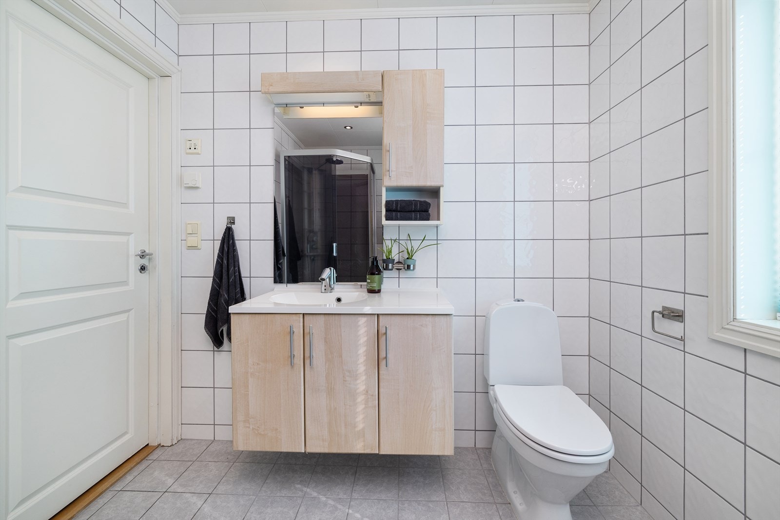 Servantinnredning med heldekkende servanttopp og speil med integrert belysning. Galleribilde