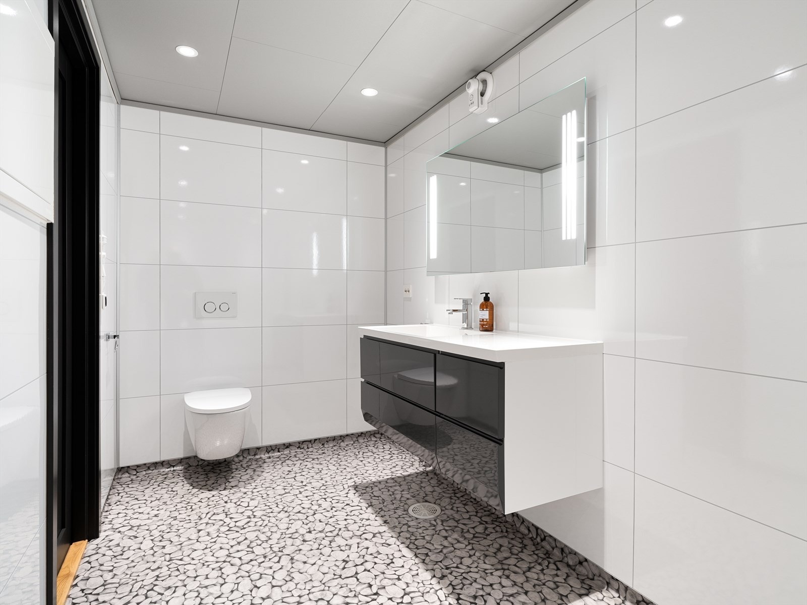 Badet er utstyrt med vegghengt toalett, baderomsmøbel og et rør-i-rør-system fra 2013. Galleribilde