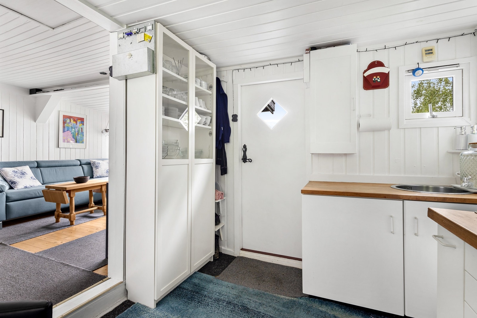 Kjøkkeninnredning med over- og underskap i hvit samt glatt utførelse - Rommet er opprinnelig byggemeldt som gang og bod Galleribilde