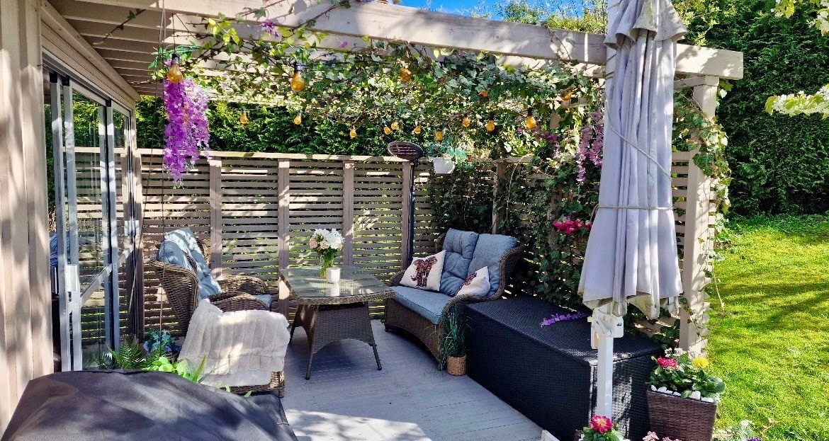 Idyllisk terrasse med pergola og vakker beplantning. Galleribilde