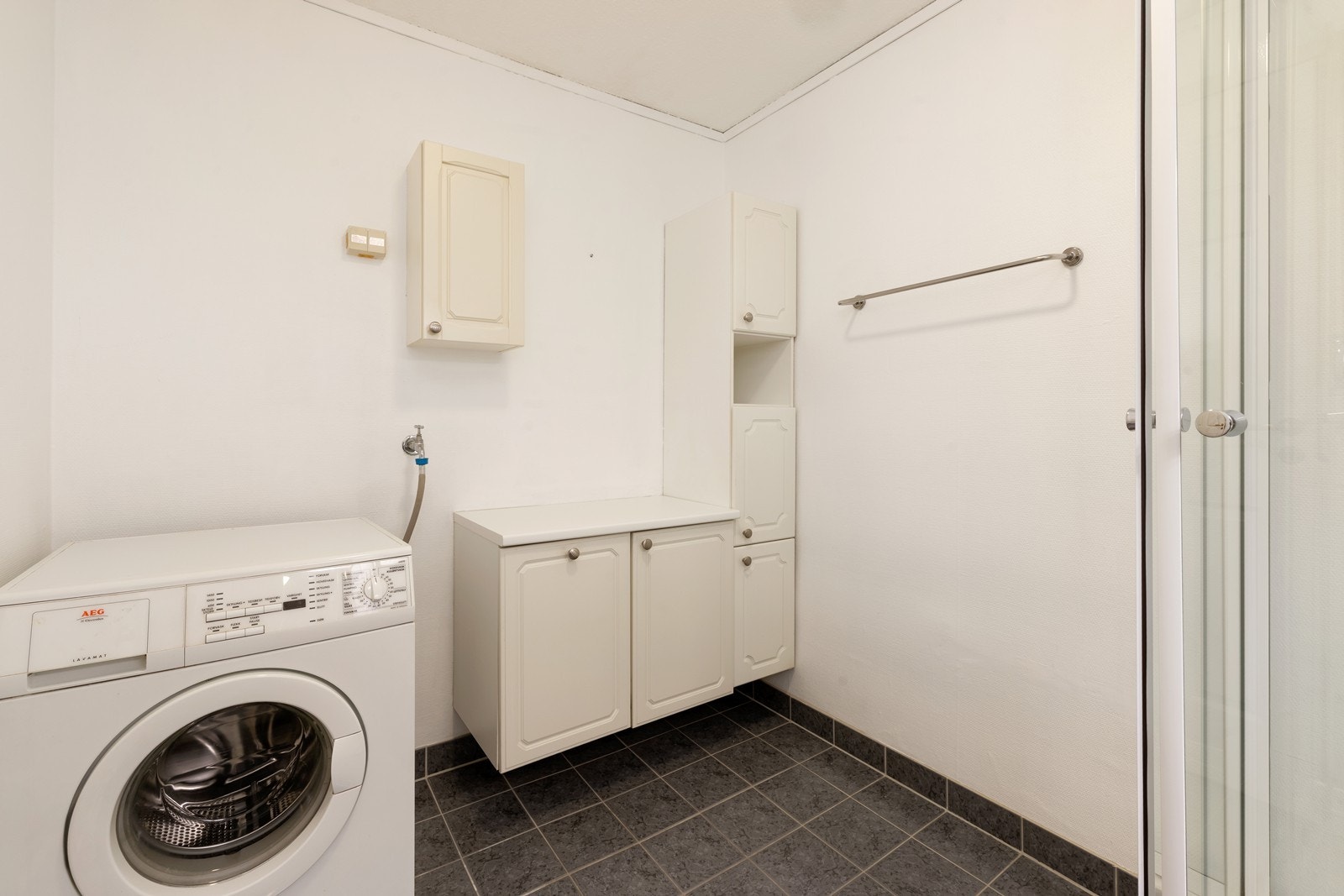 Badet har skap- og baderomsinnredning, dusjkabinett samt opplegg til vaskemaskin. Galleribilde