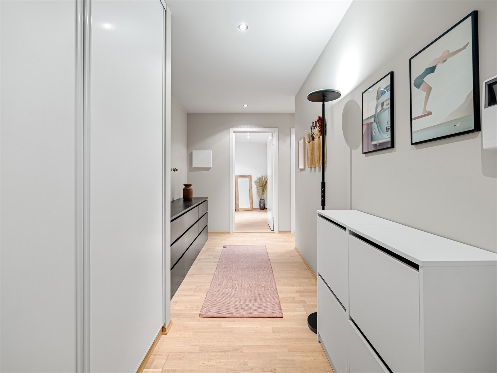 Entré med parkettgulv, malte veggflater og downlightsbelysning. Stor skyvedørsgarderobe og god plass til ekstra oppbevaringsmøblement Galleribilde