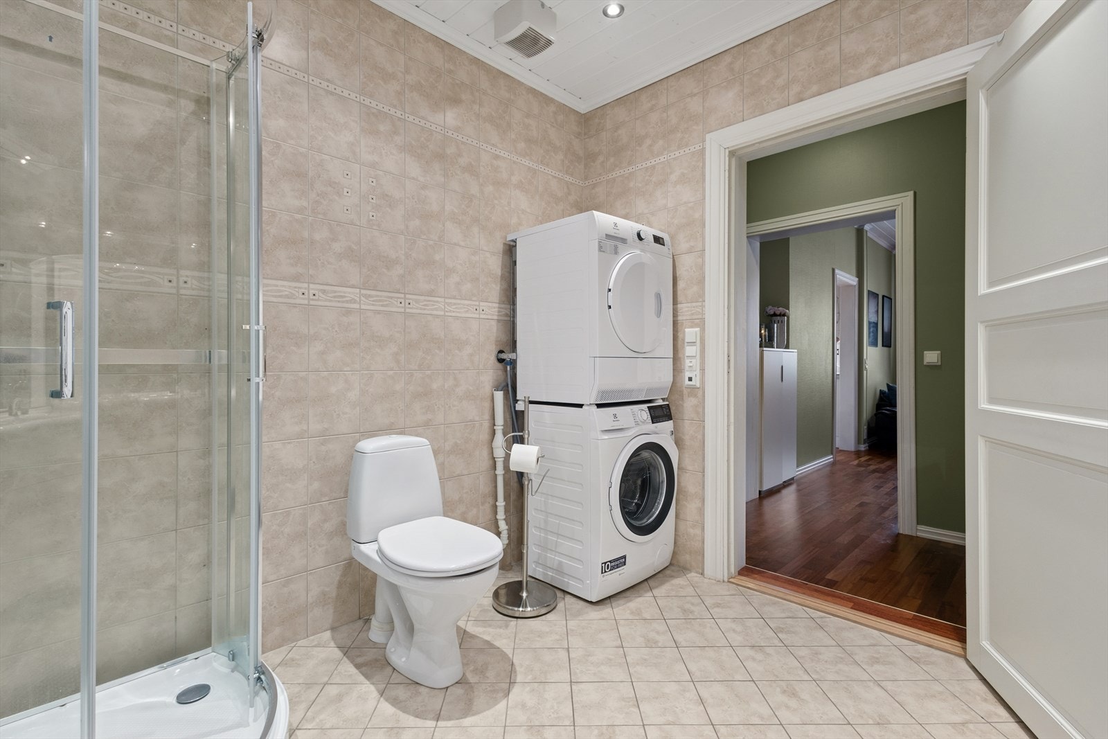 Badet har gulvmontert toalett, dusjkabinett, og opplegg for vaskemaskin. Galleribilde