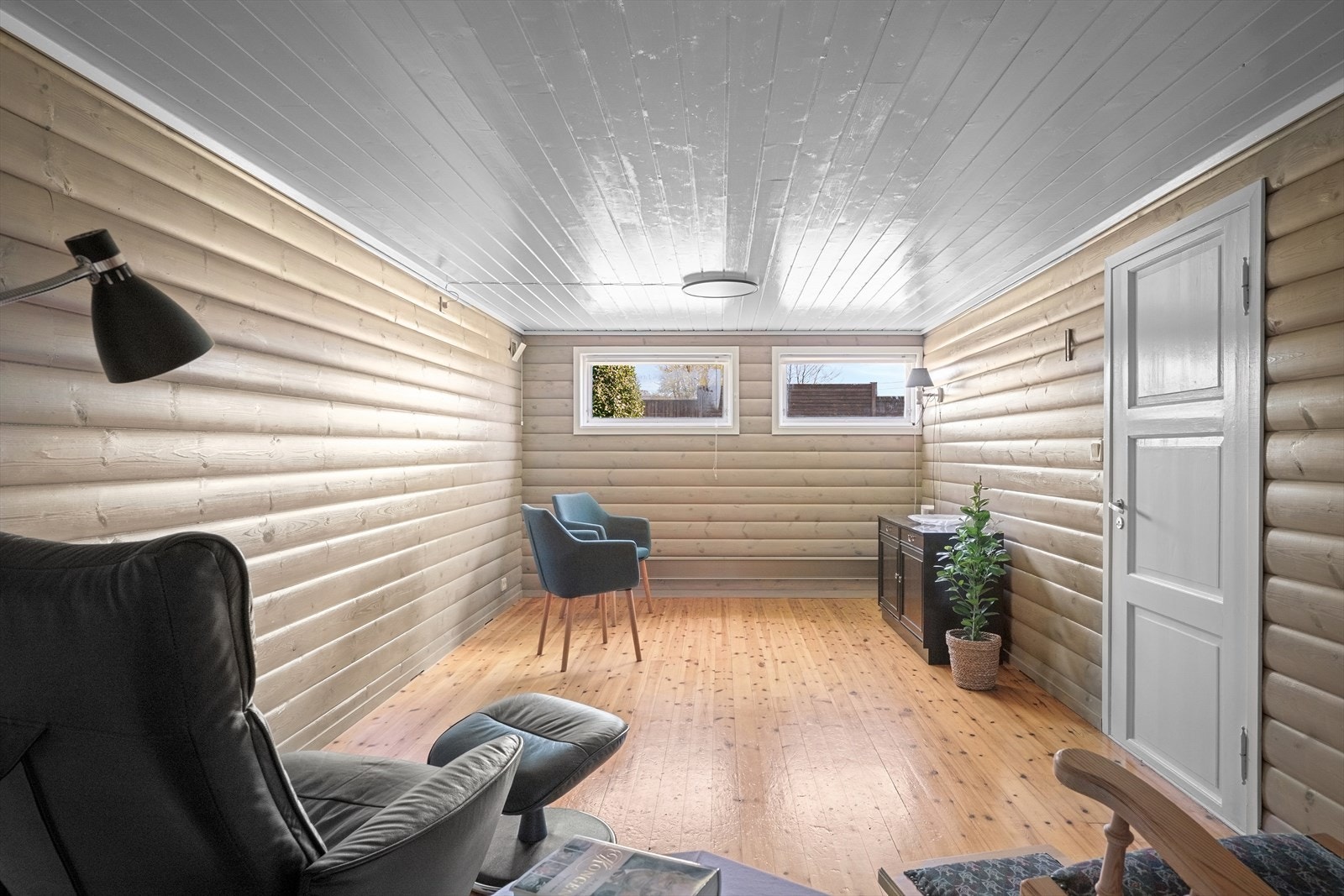 Kjellerstue med rundtømmerpanel på vegg og heltre furugulv. Kjellerstuen er ikke byggemeldt. Galleribilde