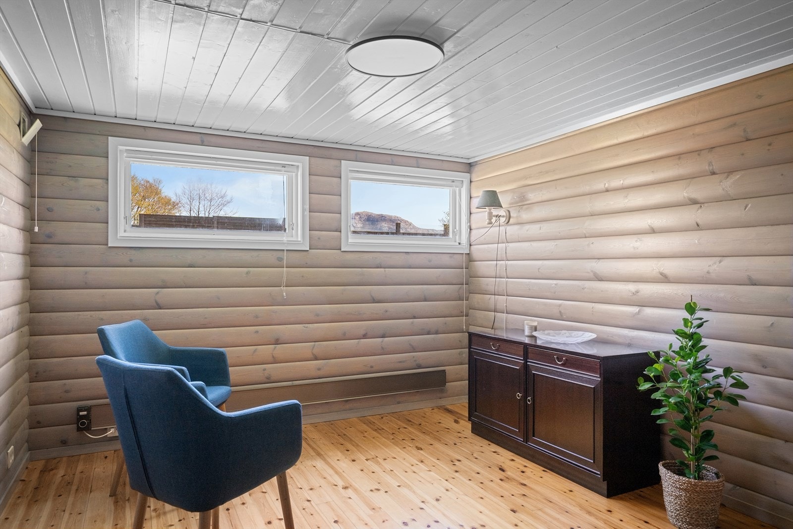 Kjellerstue med rundtømmerpanel på vegg og heltre furugulv. Kjellerstuen er ikke byggemeldt. Galleribilde