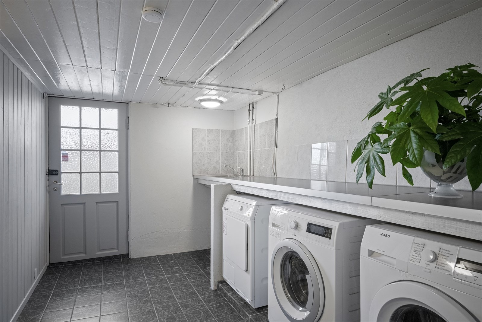 I underetasjen har man meget god lagring i 3 boder og kjølerom samt vaskerom (bildet) og bad, hobbyrom og kjellerstue som ikke er byggemeldt. Galleribilde