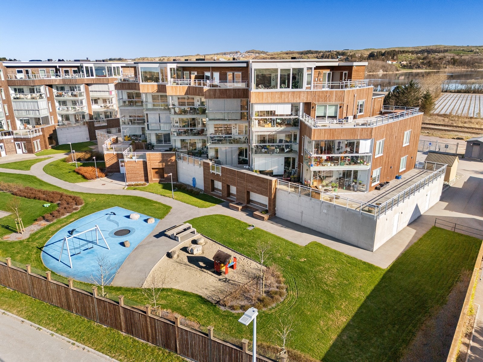 Tomten er opparbeidet med asfaltert gjeste parkering mot nordøst, fellesområde mot sørvest, pent opparbeidet og beplantet med blant annet grøntområder, grusede arealer for å samles, lekeplass og bord og benker. Galleribilde