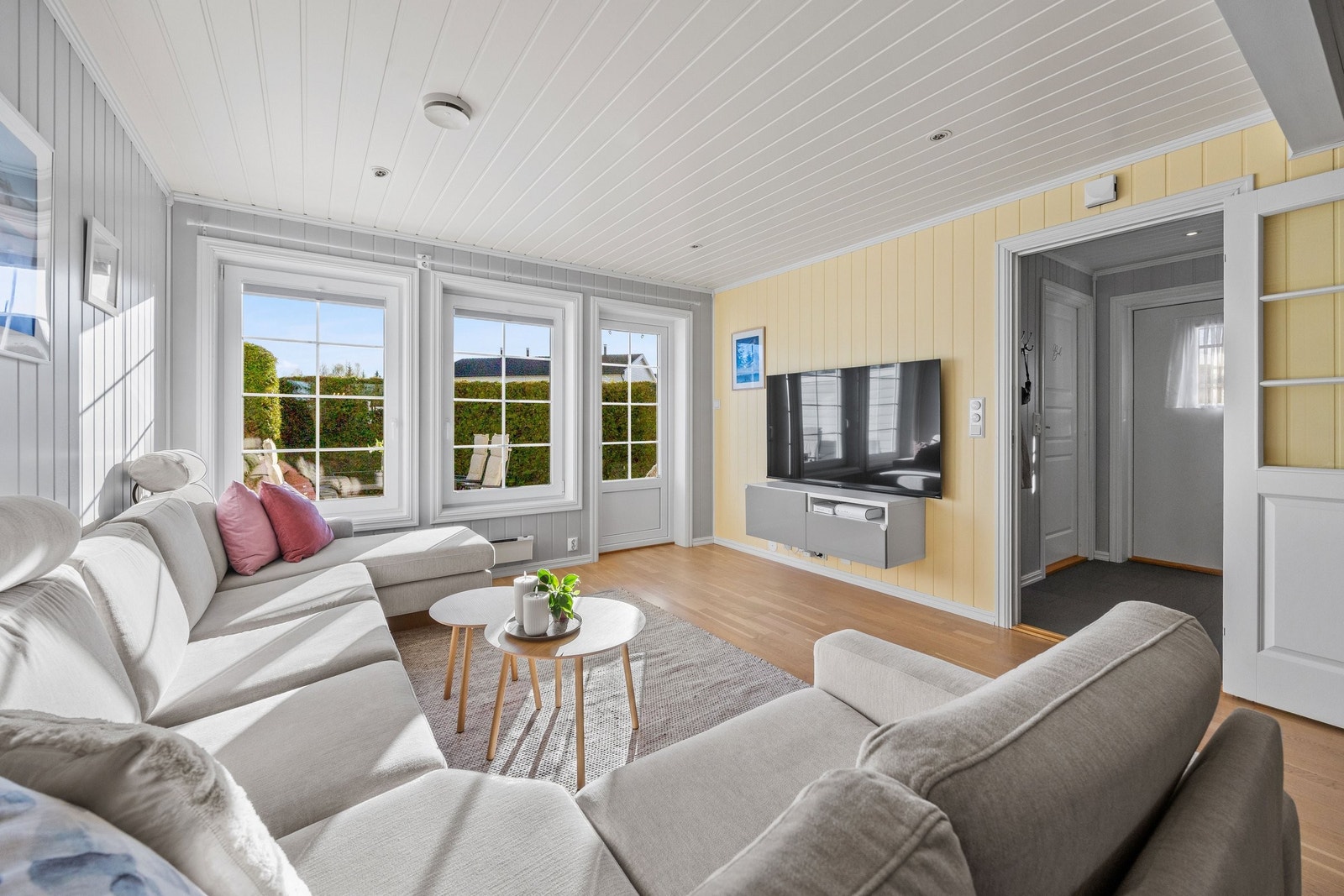 Lys og trivelig stue med store vindusflater som inviterer dagslyset inn. Galleribilde