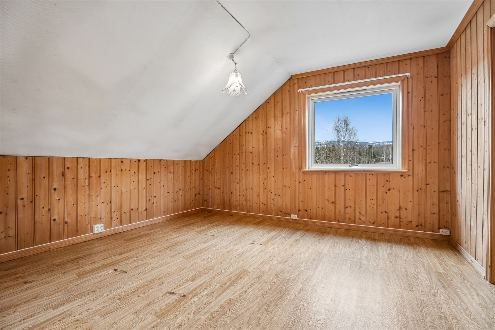 Disponibelt rom i loftetasjen med panel på veggene og skråtak. Galleribilde