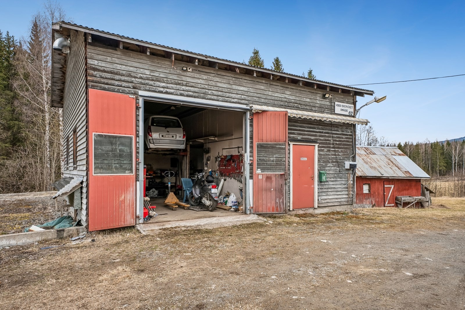 Den frittstående garasjen på 93 m² BRA inneholder verksted og boder, og gir unike muligheter for hobby, lagring eller næring. Deler av garasjen står i dag utenfor tomten. Ta kontakt med megler for mer informasjon. Galleribilde