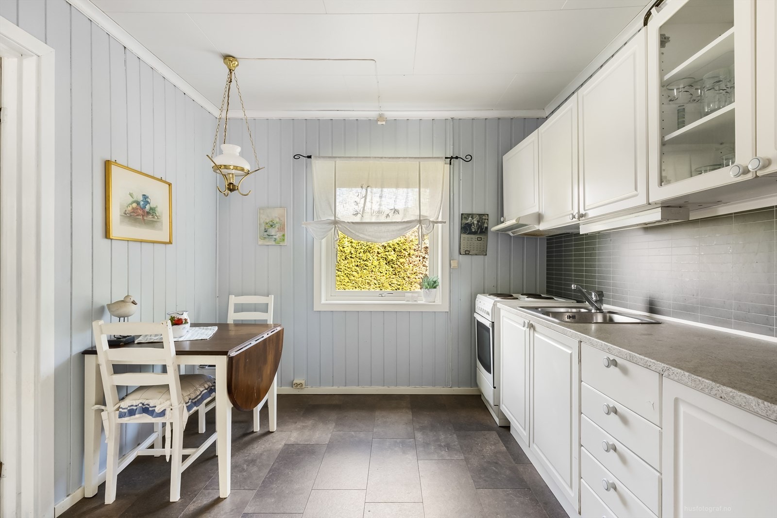 Pen kjøkkeninnredning med lyse profilerte fronter og benkeplate av laminat. Galleribilde