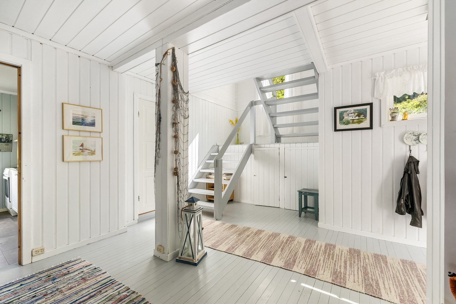 Lys og romslig entré med malt tregulv og panel på vegg og her passer det fint å innrede med knagger og skohyller. Trappen fører deg opp til soverommene. Galleribilde