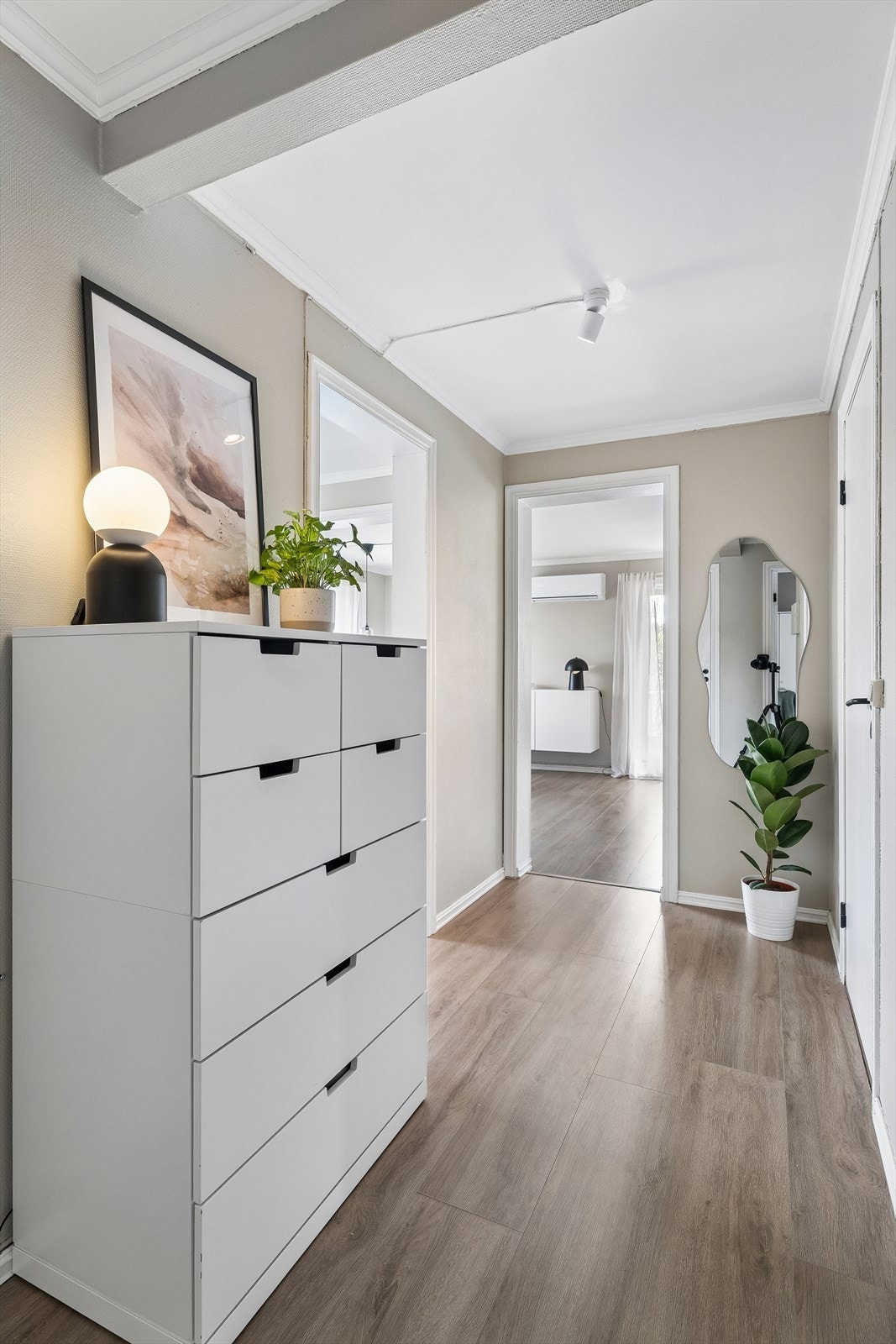 Fra gangen er det tilgang til leilighetens øvrige rom. Det gjennomgående laminatgulvet binder rommene sammen. Galleribilde