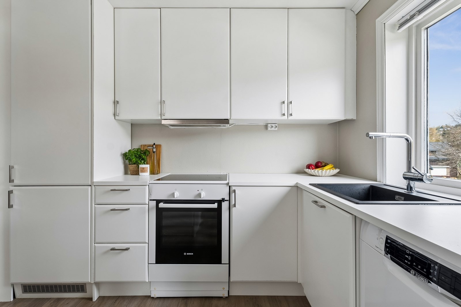 Kjøkkeninnredningen fra 2022 har glatte, malte fronter og laminert benkeplate med nedfelt vaskekum. Galleribilde