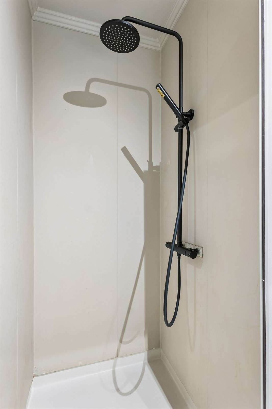 Detalj fra dusjsonen med vegghengt dusjarmatur. Galleribilde