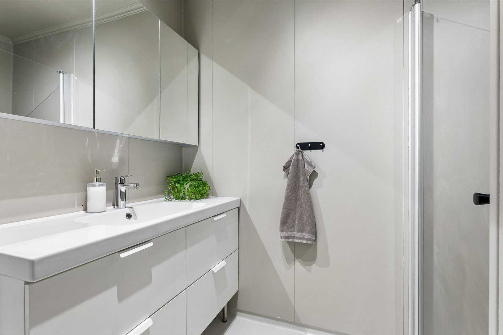 Badet ble oppgradert i 2022 med nytt servantskap og vegghengt dusj med skjermdør i glass. Galleribilde
