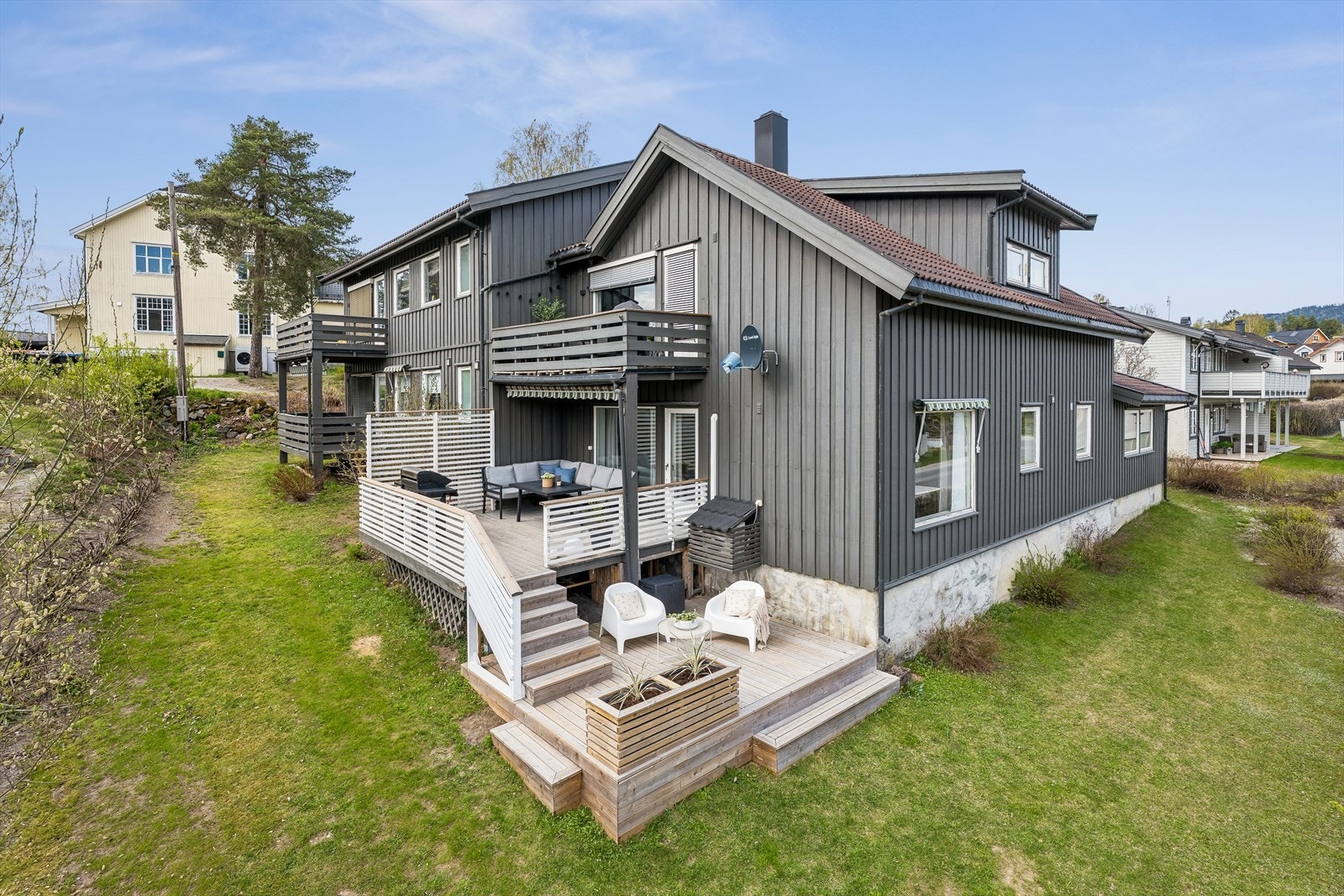 Eiendommen har en felles, svakt skrånende tomt som er opparbeidet med plen og beplantning. Galleribilde