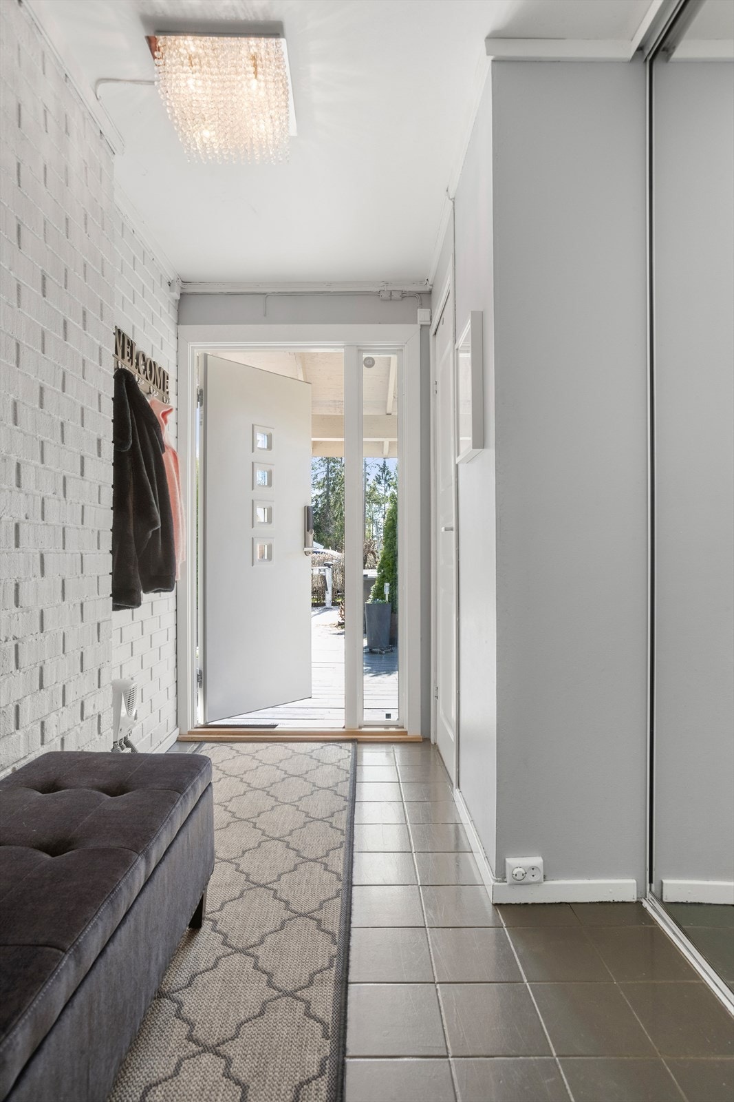 Lys og innbydende entré med skyvedørsgarderobe med speilfronter. Galleribilde