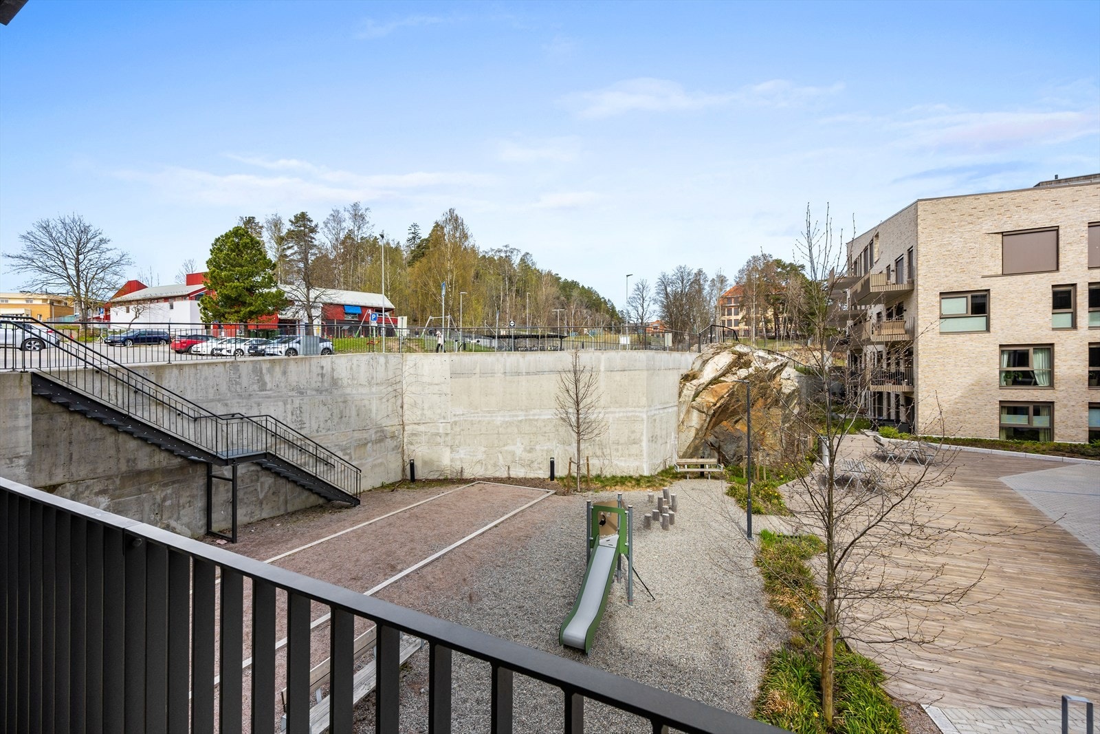 Fra balkongen ser man ned på sameiets lekeplass og fellesarealer. Galleribilde