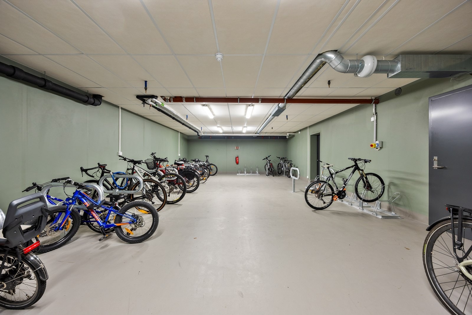 Stor, felles sykkelparkering med servicemuligheter i underetasjen. Galleribilde