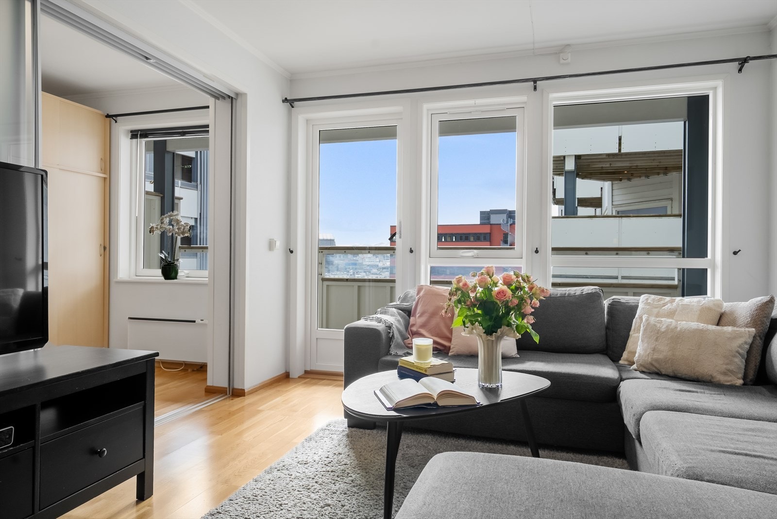 Lys stue med store vindusflater som slipper inn rikelig med naturlig dagslys Galleribilde