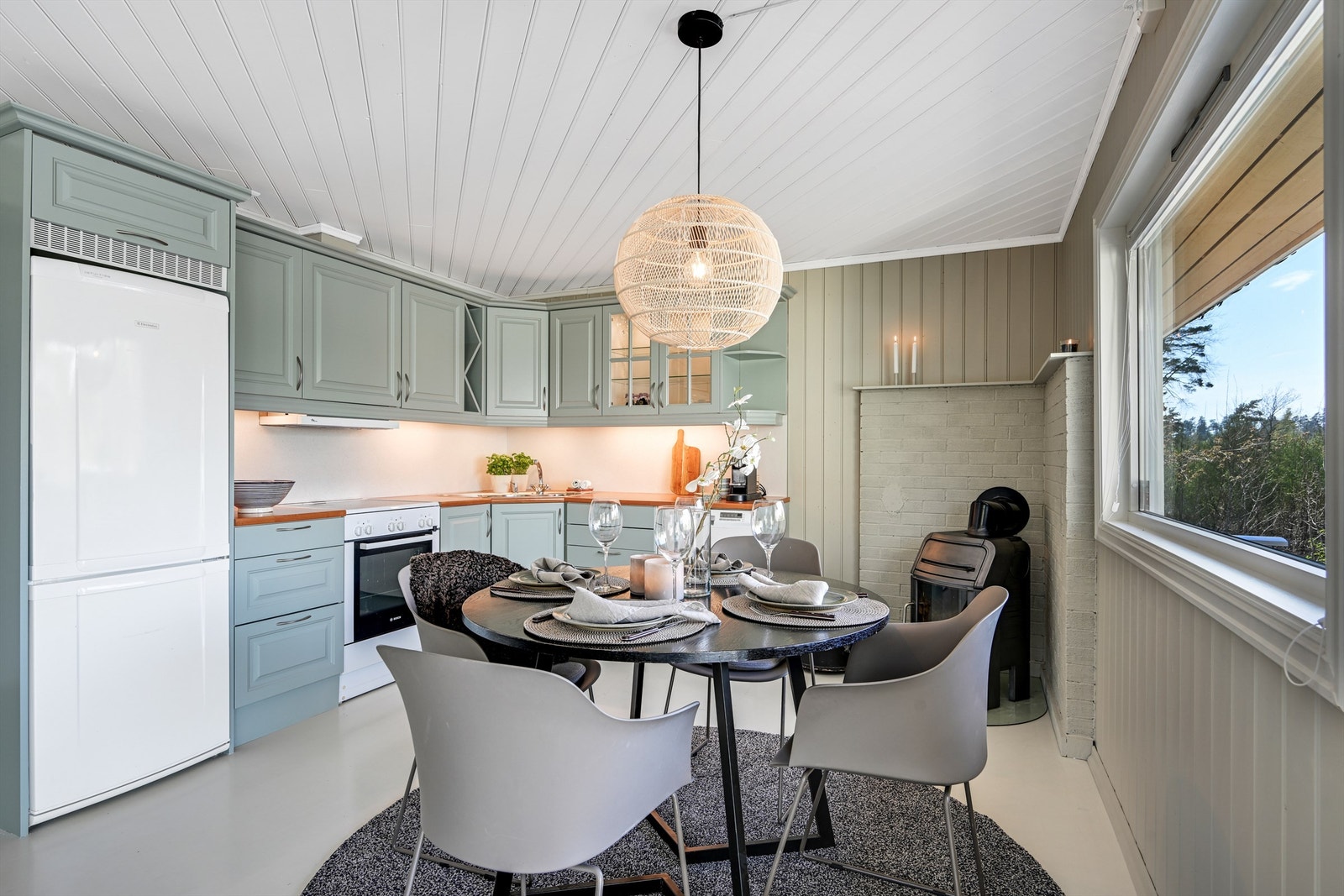 Koselig kjøkken med malte, profilerte fronter og en benkeplate i laminat. kjøkkenventilatoren har avtrekk ut. Det er plass til frittstående kjøl/fryseskap, oppvaskmaskin og komfyr. Galleribilde