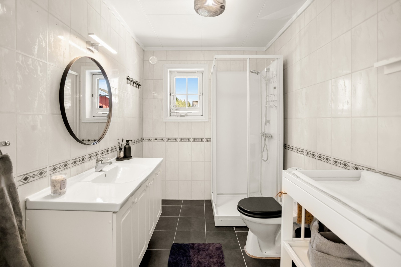 Badet har flislagt gulv og baderomsplater på veggene, med himling av Tak-ess-plater. Galleribilde