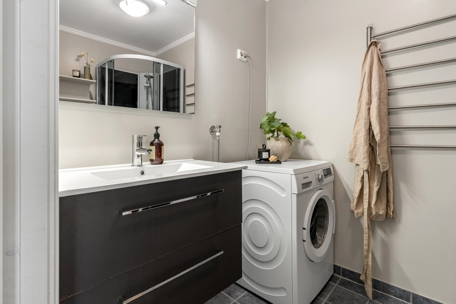 Badet har dusjkabinett, opplegg for vaskemaskin og plass til tørketrommel