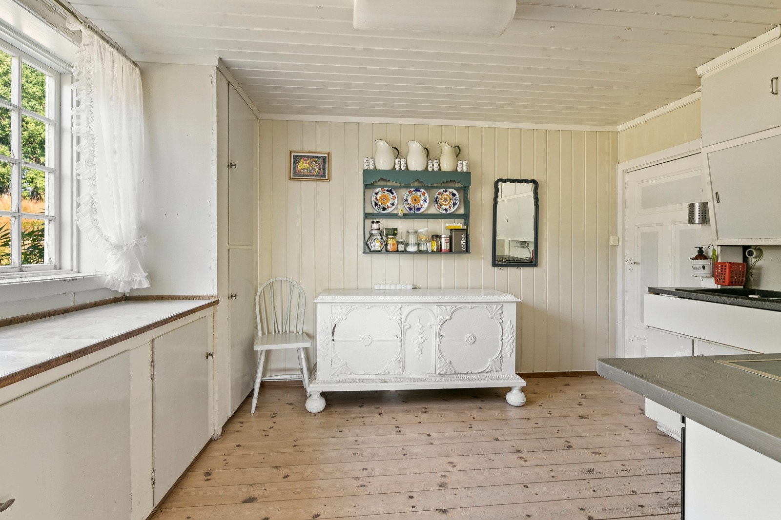 Som et separat rom med originalt tregulv og klassisk innredning fremstår kjøkkenet som et sjarmerende og historisk rom Galleribilde