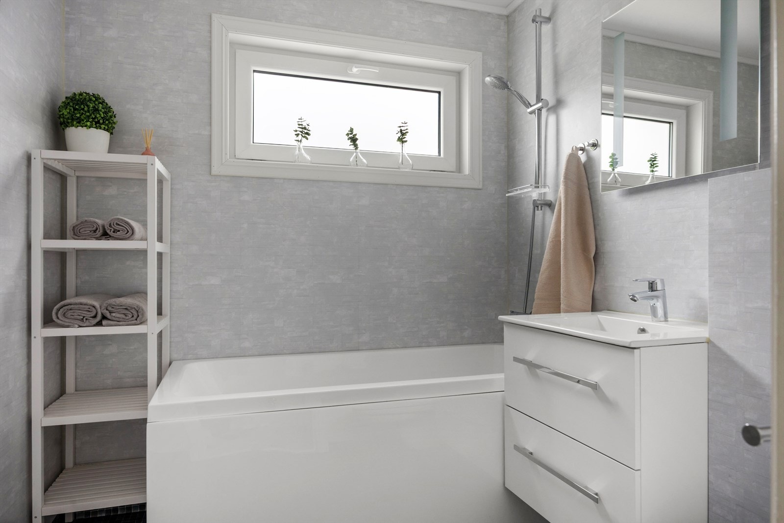 Badet i første etasje er lyst og fint og inneholder badekar, toalett og en seksjon med servant. Galleribilde