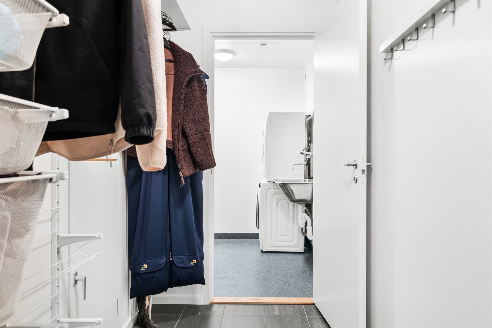 Fra garderoben i underetasjen er det inngang til et separat vaskerom og en praktisk bod innerst i garasjen. Galleribilde