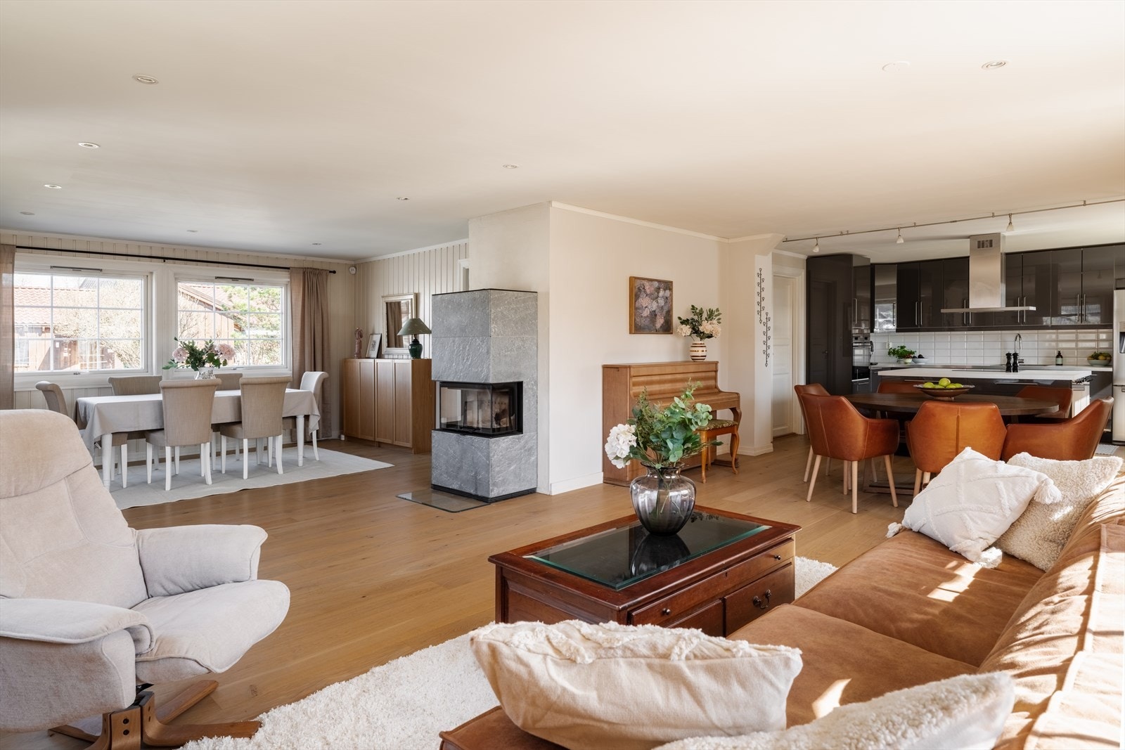 Store vindusflater slipper inn godt med naturlig lys, og en hyggelig peis fra Contura med kleberstein skaper både varme og en koselig atmosfære. Galleribilde