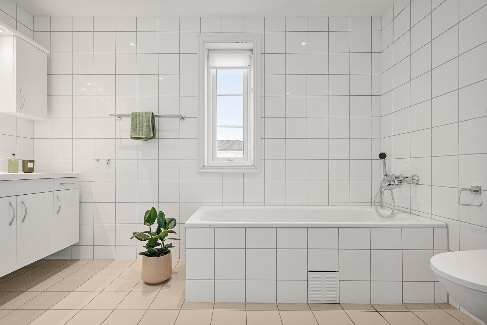 Stort bad fra byggeår med veggmontert toalett, innfliset badekar og dusjhjørne. Galleribilde